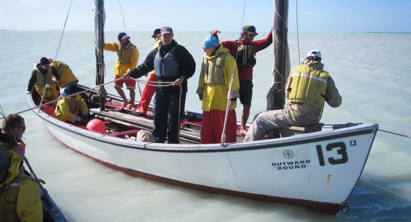 a group of veterans practice sailing techniques on an outward bound expedition 